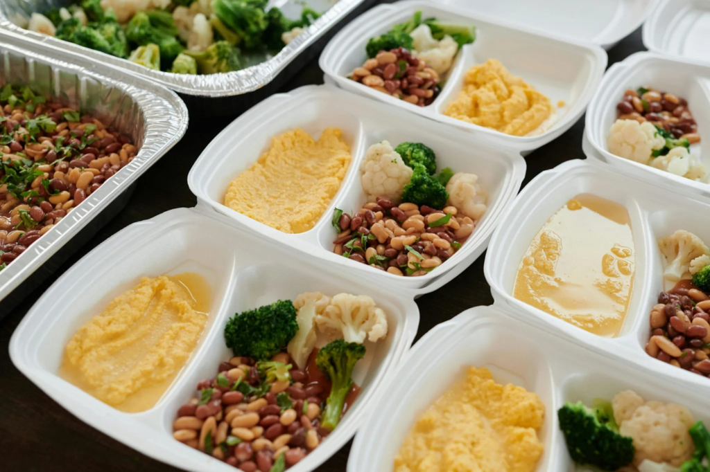 Food spread consisting of eggs, nuts, and broccoli. 