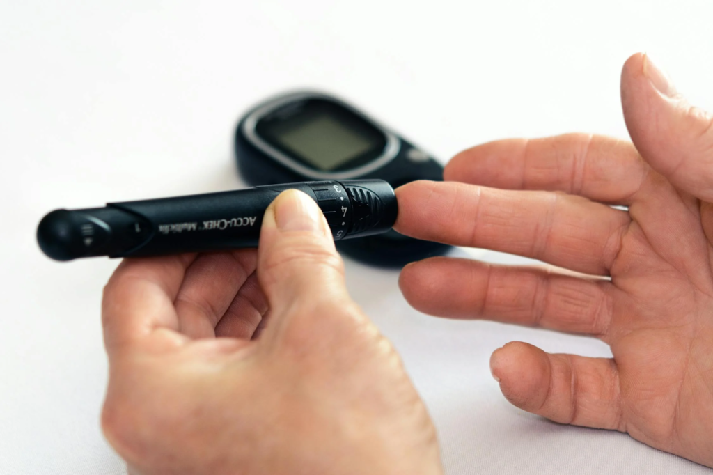 Person testing their own blood sugar using an Accu-Chek test kit.