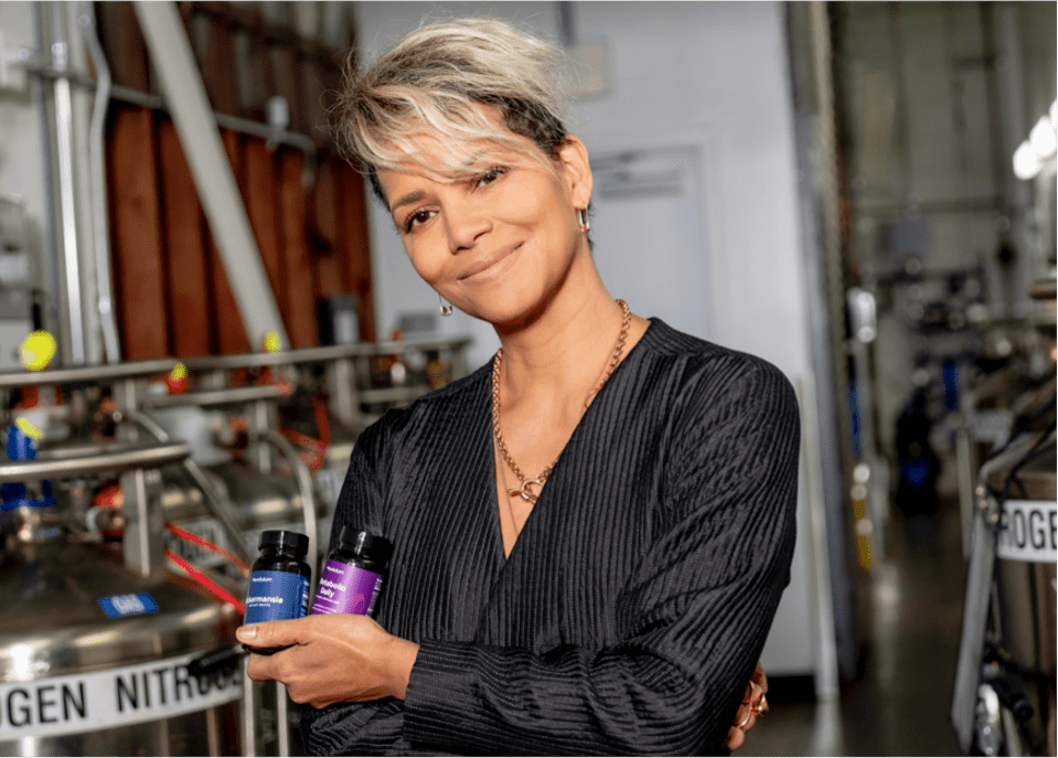 Halle Berry pictured holding two Pendulum supplement bottles.