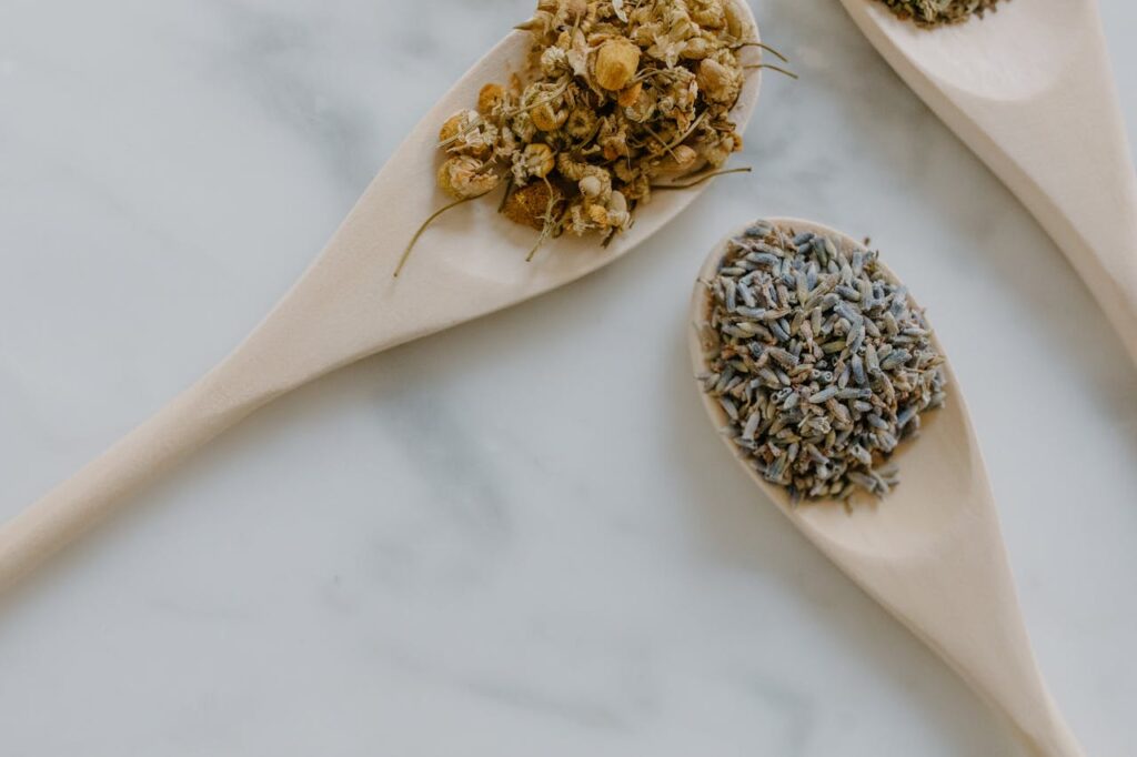 Wooden spoons filled with dried chamomile flowers and lavender.
