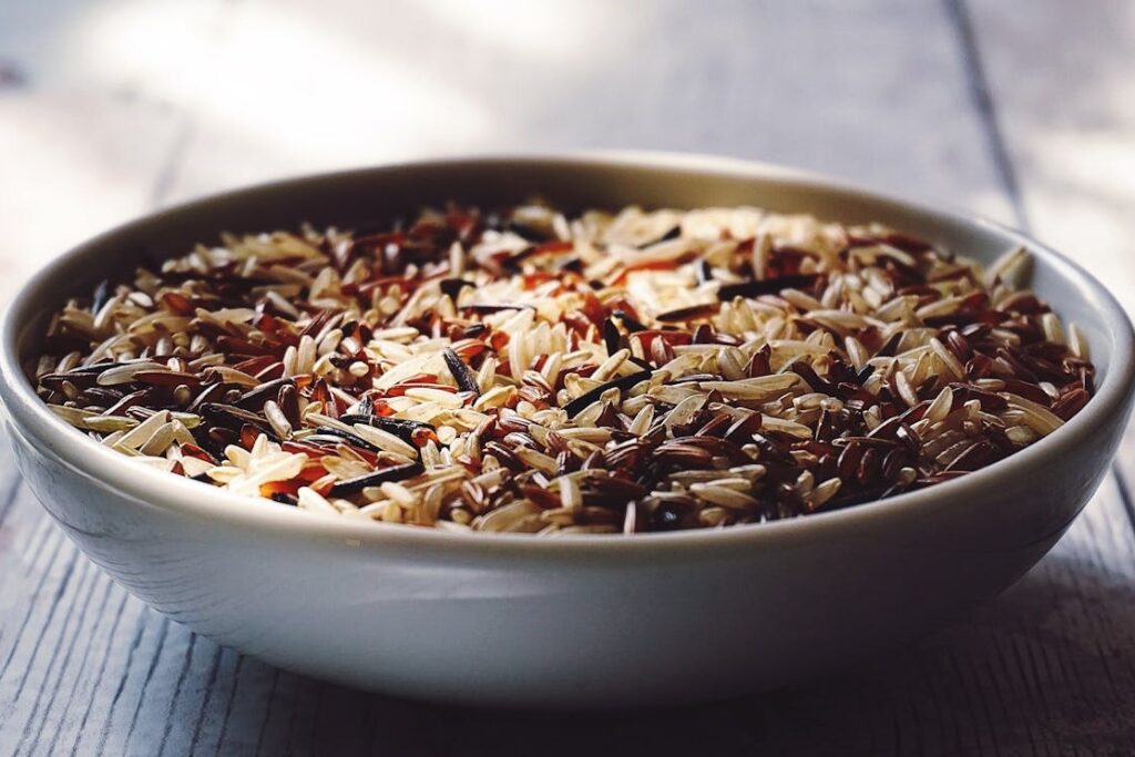 A bowl of mixed wild and brown rice placed on a wooden table.