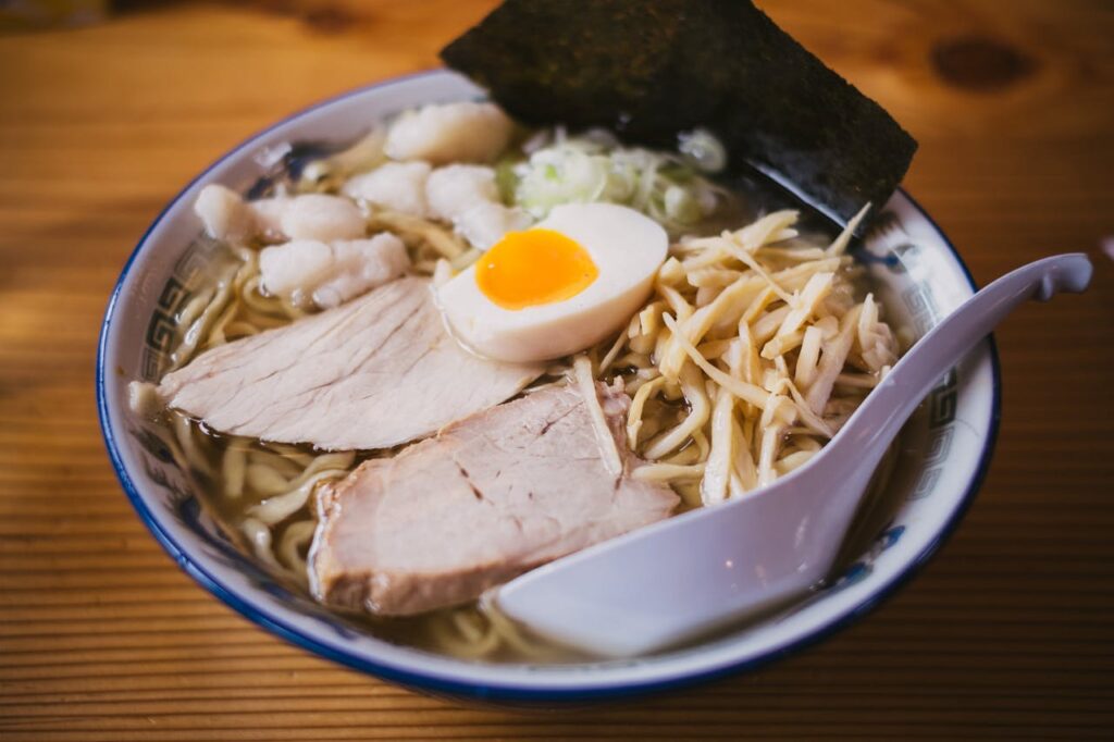 A bowl of ramen with lean meat, half-boiled egg, bamboo shoots, and seaweed.