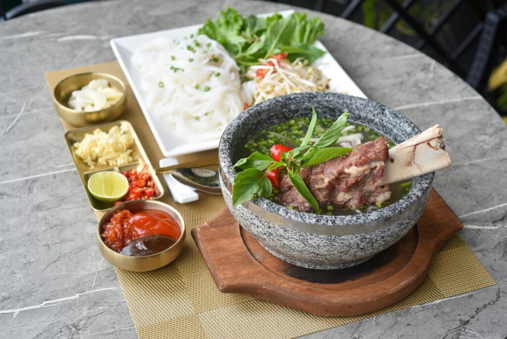 A hearty bowl of bone broth served with fresh vegetables.