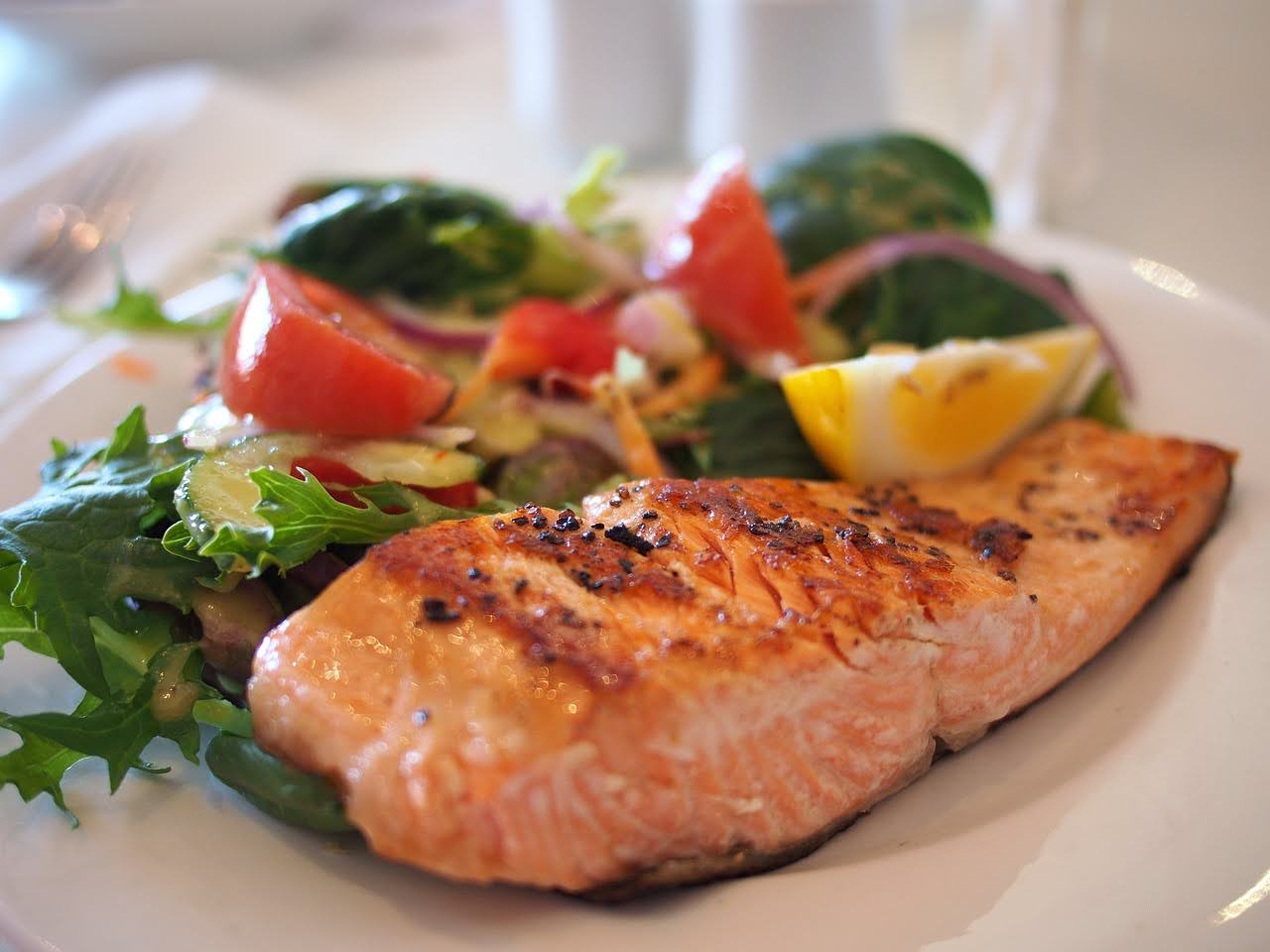 A plate of grilled salmon served with a fresh salad.