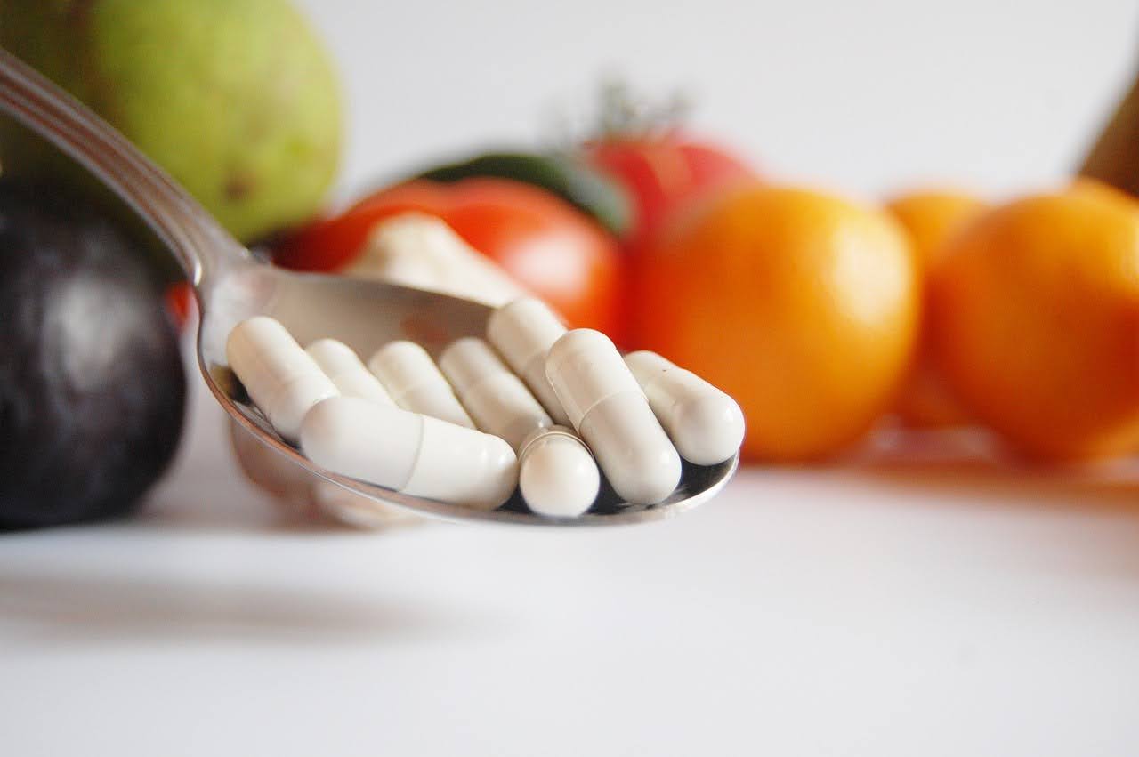 A spoon filled with L-ornithine capsules.