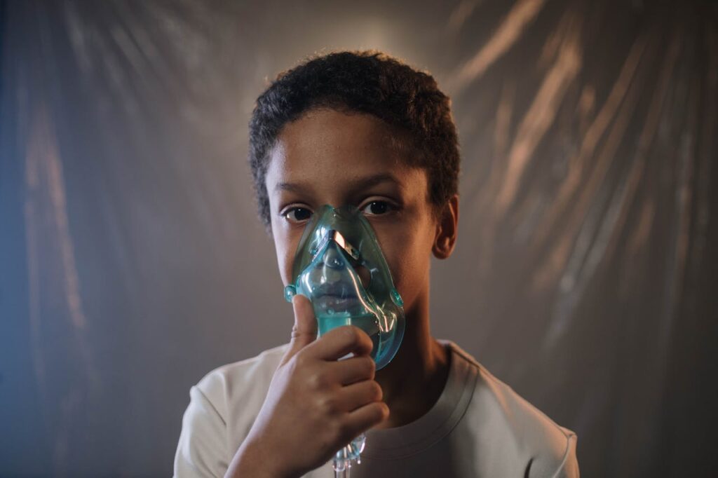 Child using an oxygen mask for breathing support.