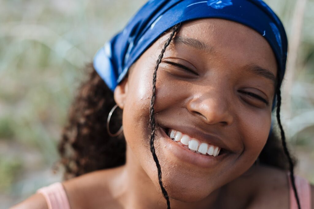 Close-up of a smiling woman wearing a blue headscarf.